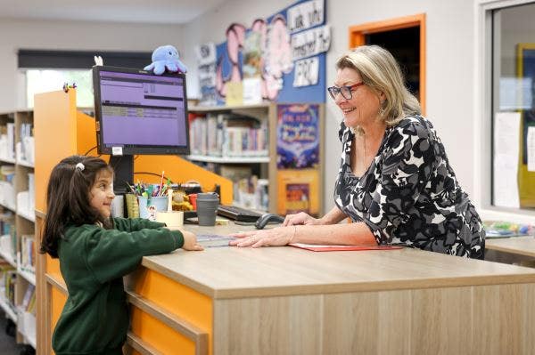 A student and teacher-librarian in the library