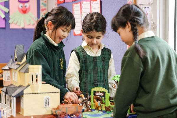 3 students playing with a model