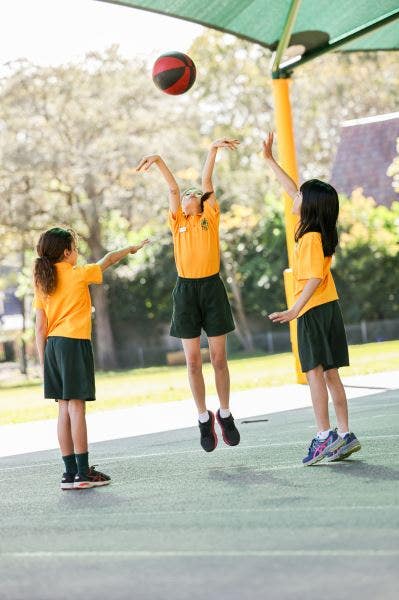 3 students playing basketball