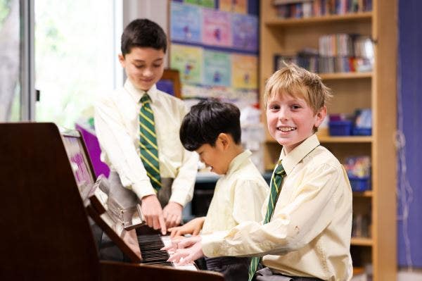 3 students at a piano